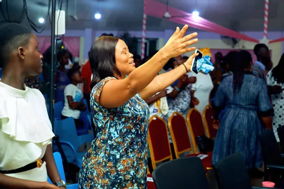 A woman extending her arms during congregational worship
