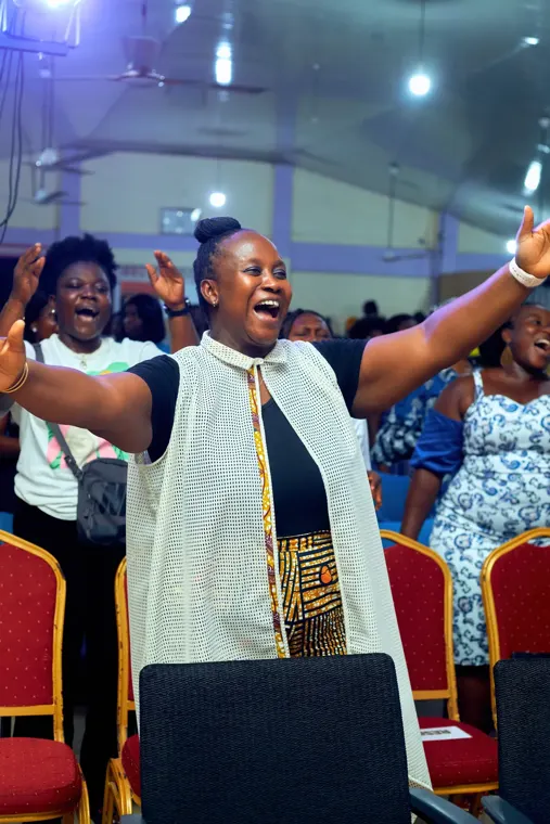 A worshipper with both arms extended at Tokens of Praise 2025