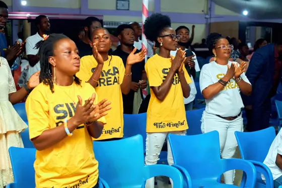 Attendees in yellow shirts singing in the congregation