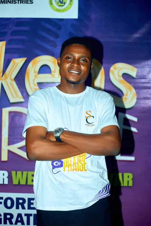 An attendee in a white shirt standing in front of the event backdrop