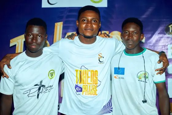 Three attendees posing together in front of the event backdrop