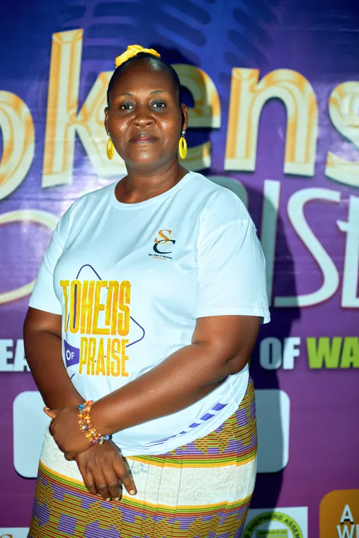 An attendee in a white shirt posing in front of the event backdrop